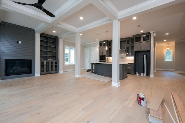 living room with built in shelves, beam ceiling, ornamental molding, ceiling fan, and a fireplace