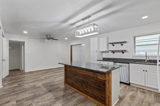 kitchen with sink, stainless steel dishwasher, pendant lighting, and white cabinetry