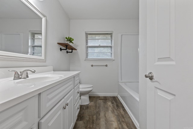 bathroom featuring toilet, vanity, and hardwood / wood-style floors