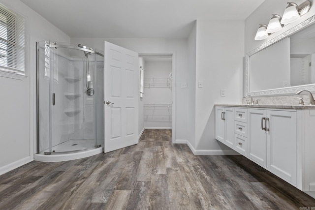 bathroom with a shower with shower door, wood-type flooring, and vanity