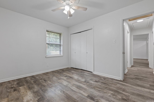 unfurnished bedroom featuring ceiling fan, hardwood / wood-style floors, and a closet