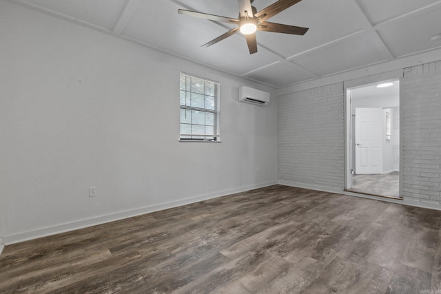 spare room featuring hardwood / wood-style flooring, a wall mounted AC, brick wall, ceiling fan, and coffered ceiling