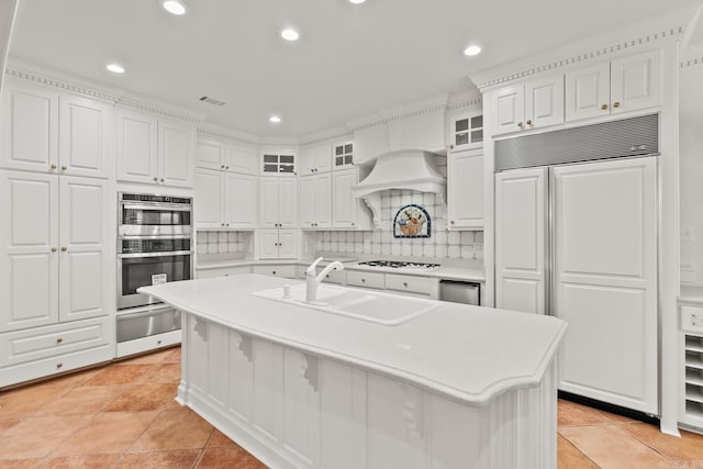 kitchen with sink, white cabinets, paneled fridge, a center island with sink, and white gas cooktop