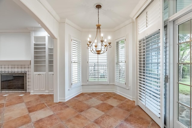 unfurnished dining area with built in shelves, ornamental molding, and a chandelier