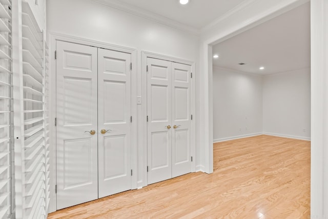 hallway with ornamental molding and light wood-type flooring