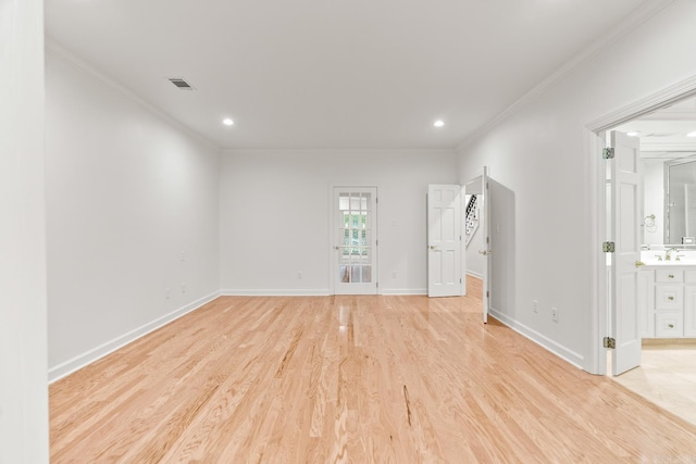 empty room with crown molding and light hardwood / wood-style flooring