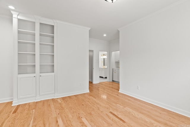 unfurnished bedroom featuring ensuite bath, ornamental molding, and light wood-type flooring