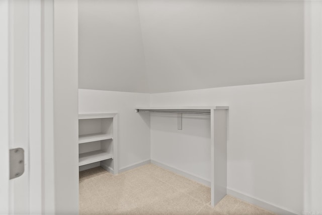 walk in closet featuring light colored carpet and vaulted ceiling