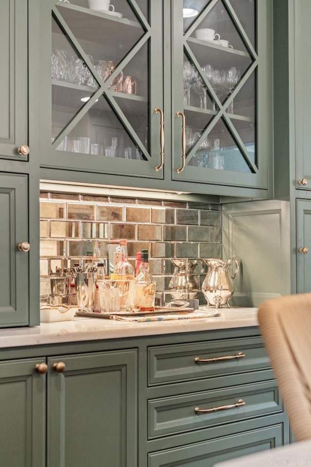 bar featuring decorative backsplash and green cabinets