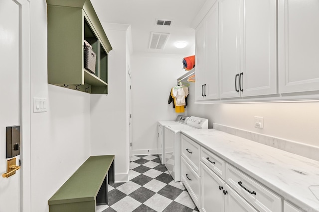 clothes washing area featuring separate washer and dryer, cabinets, and crown molding