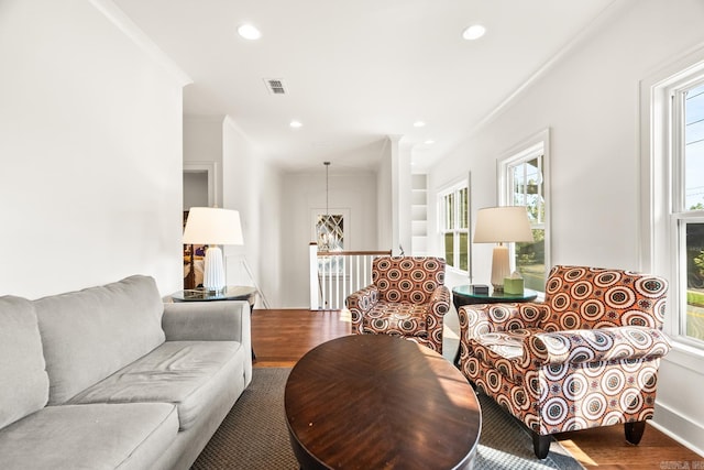 living room with crown molding and hardwood / wood-style flooring