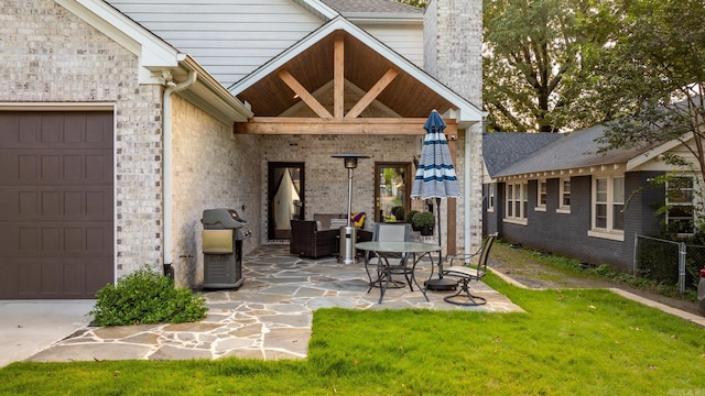 rear view of house with a yard, a garage, and a patio area