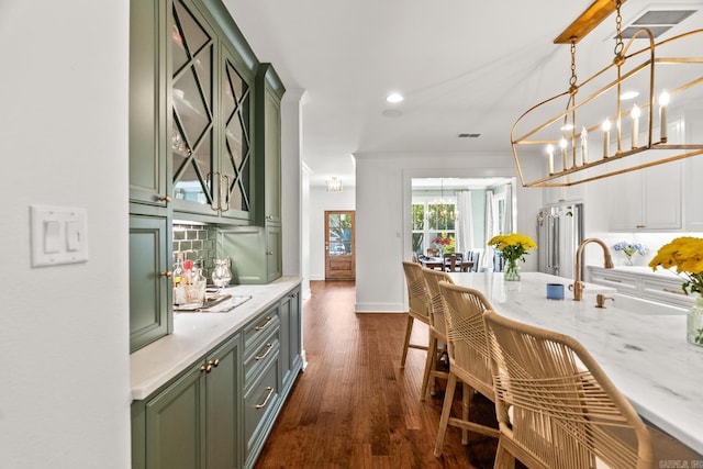 interior space featuring a chandelier, dark hardwood / wood-style floors, decorative light fixtures, high end refrigerator, and sink