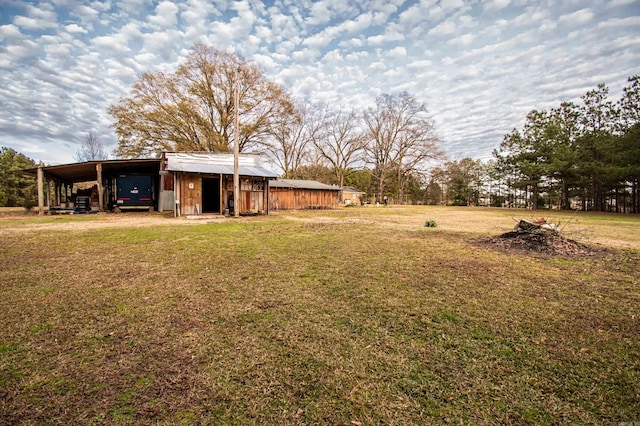 view of yard featuring a carport and an outdoor structure