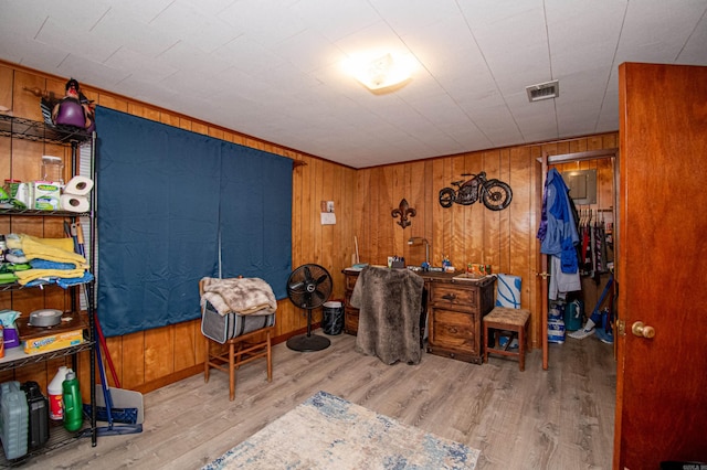 miscellaneous room with wooden walls and light hardwood / wood-style floors