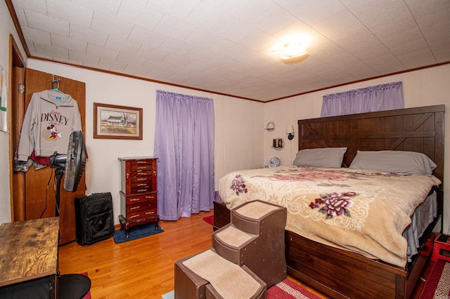 bedroom featuring crown molding and hardwood / wood-style flooring