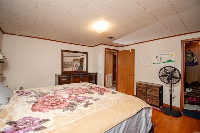 bedroom with ornamental molding and light hardwood / wood-style flooring