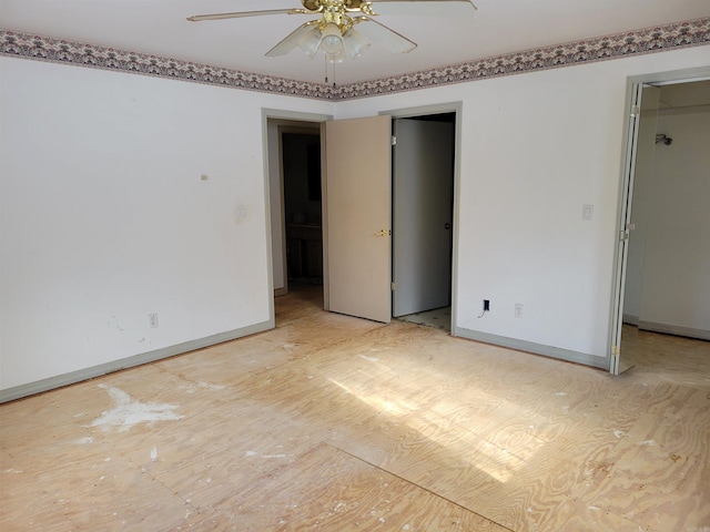 unfurnished bedroom featuring ceiling fan and a spacious closet