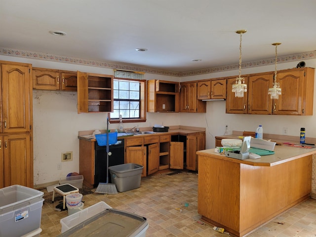 kitchen featuring sink, kitchen peninsula, a notable chandelier, and hanging light fixtures