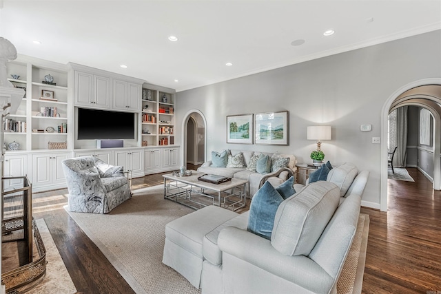 living room featuring wood-type flooring, crown molding, and built in features