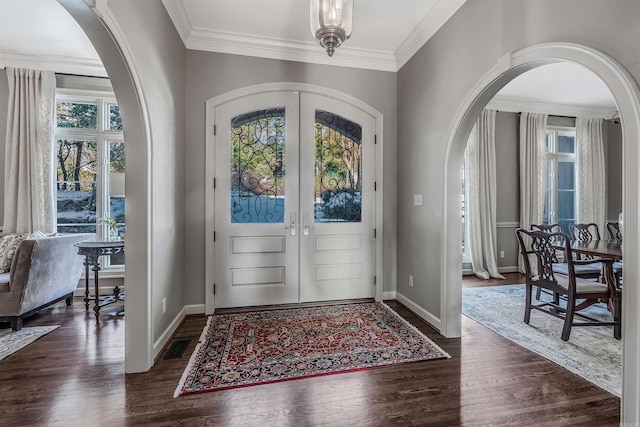 entryway featuring ornamental molding, dark wood-type flooring, and french doors