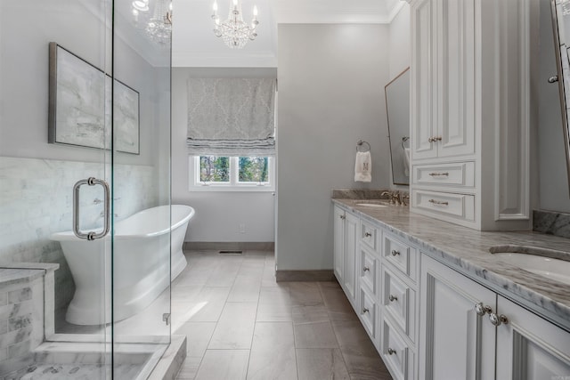 bathroom featuring an inviting chandelier, crown molding, vanity, and a bathing tub