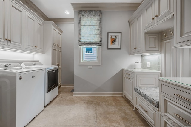 washroom with washer and clothes dryer, ornamental molding, and cabinets