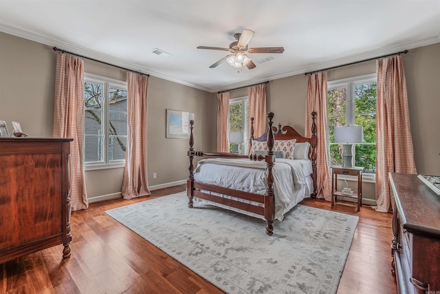 bedroom featuring ceiling fan, crown molding, light hardwood / wood-style floors, and multiple windows