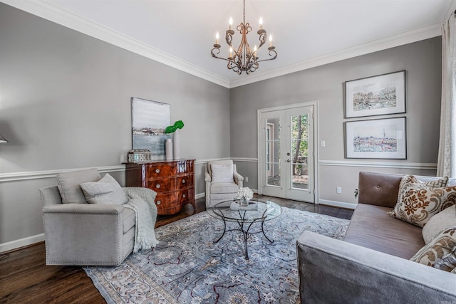 living room featuring french doors, dark hardwood / wood-style flooring, an inviting chandelier, and ornamental molding