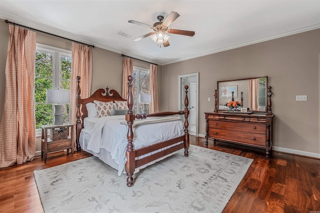 bedroom with a closet, crown molding, ceiling fan, dark wood-type flooring, and a walk in closet