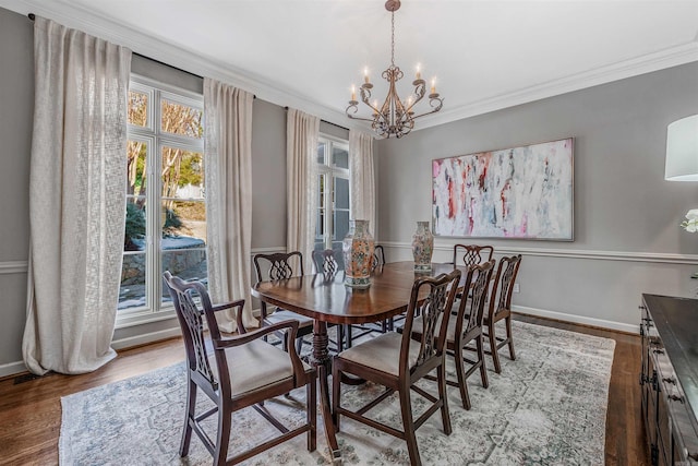 dining room featuring an inviting chandelier, ornamental molding, and hardwood / wood-style flooring