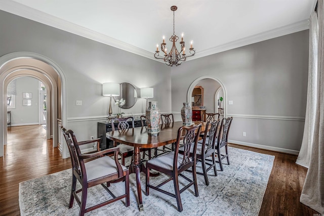 dining space with a chandelier, ornamental molding, and dark hardwood / wood-style floors