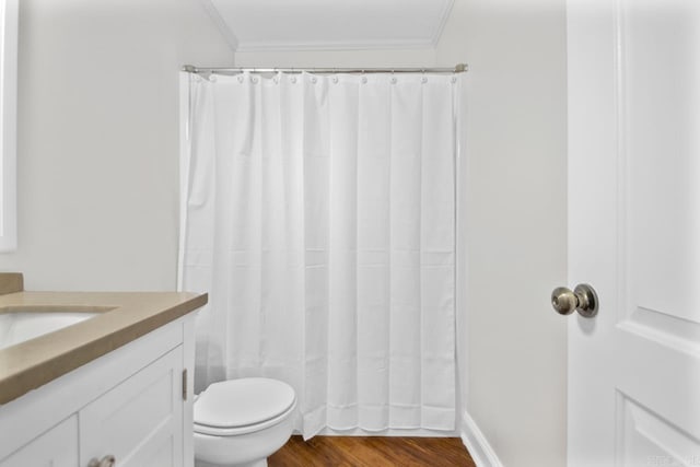 bathroom with hardwood / wood-style floors, toilet, vanity, a shower with curtain, and ornamental molding