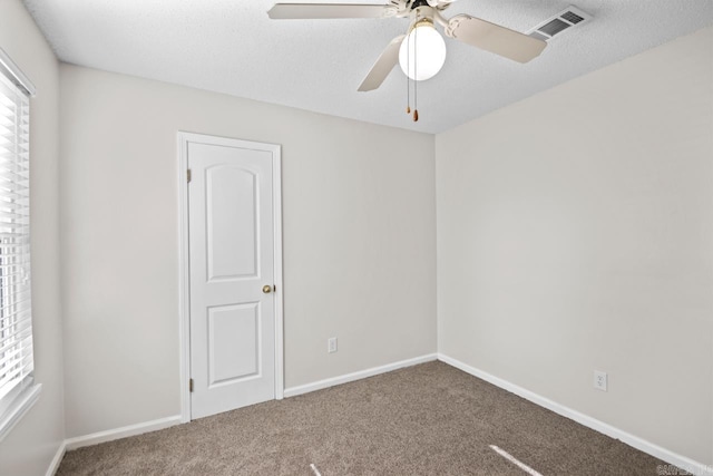 carpeted spare room with ceiling fan