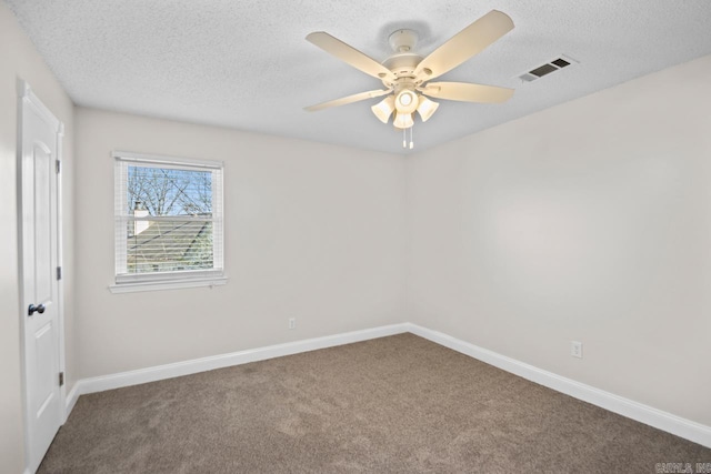 carpeted spare room featuring a textured ceiling and ceiling fan