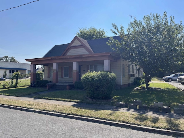 view of front of property featuring covered porch and a front lawn