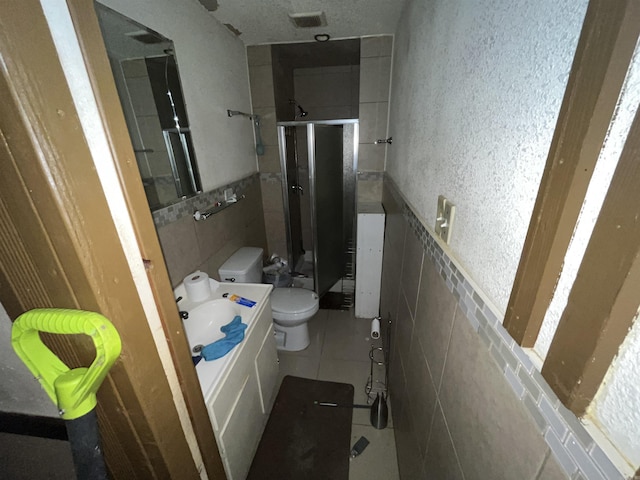 bathroom featuring vanity, an enclosed shower, tile patterned flooring, and toilet