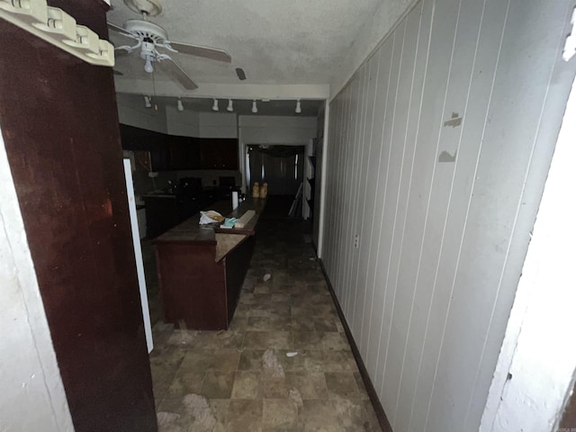 kitchen featuring wooden walls and ceiling fan