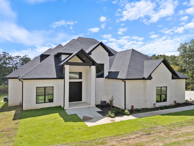 view of front of property with central AC unit and a front lawn