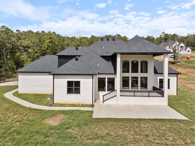 rear view of house with a patio and a yard