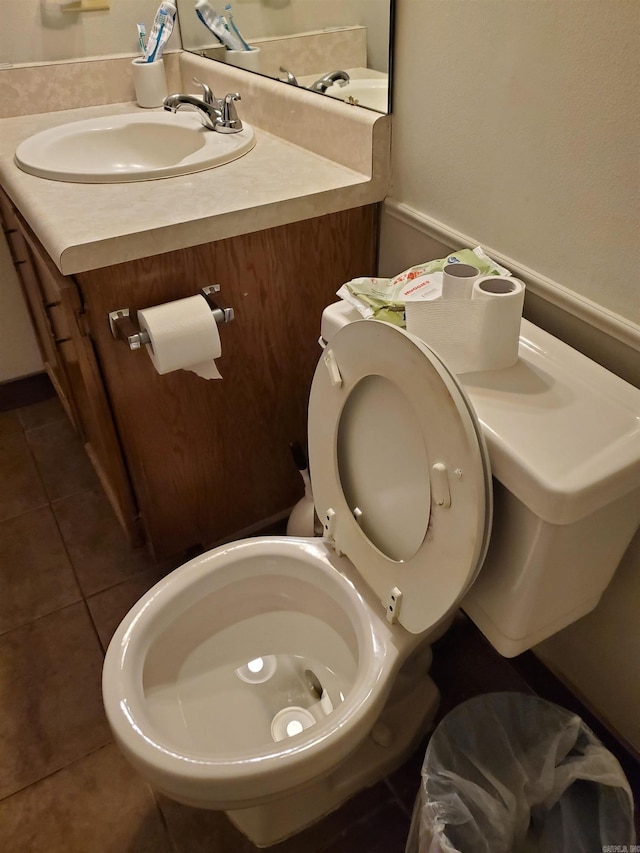 bathroom with toilet, vanity, and tile patterned floors