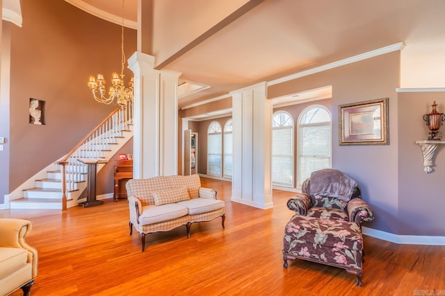 living area featuring ornamental molding, an inviting chandelier, and wood-type flooring