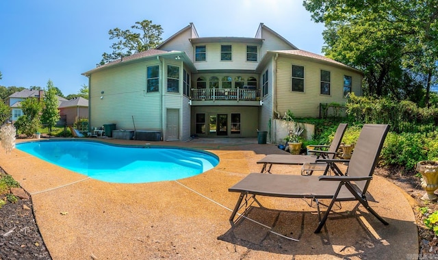 back of house featuring a balcony, a patio, and a fenced in pool