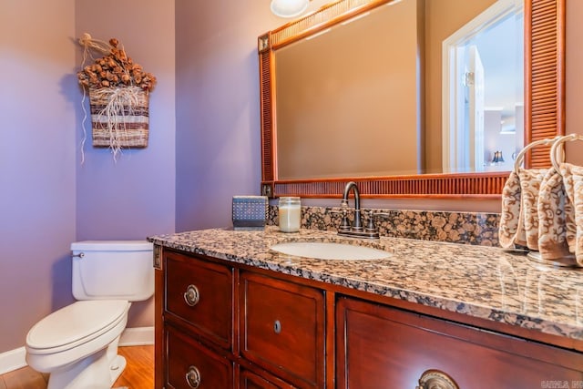 bathroom with hardwood / wood-style flooring, vanity, and toilet