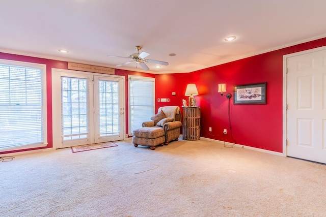 sitting room featuring carpet flooring, ceiling fan, and crown molding