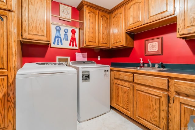 laundry area with sink, washer and dryer, and cabinets