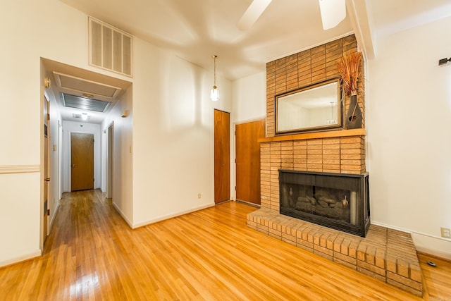 unfurnished living room with a fireplace, ceiling fan, and wood-type flooring