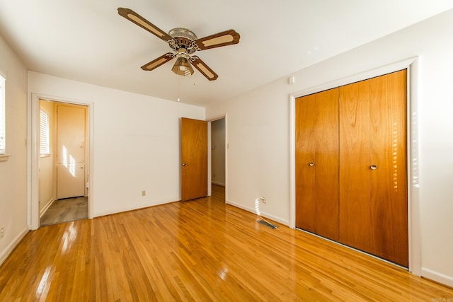 unfurnished bedroom with ceiling fan, light hardwood / wood-style flooring, and a closet