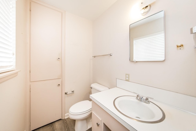 bathroom featuring toilet, wood-type flooring, and vanity