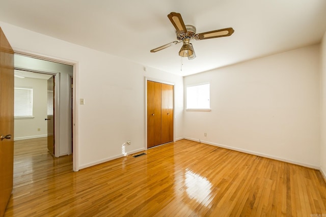 unfurnished bedroom with a closet, ceiling fan, and light hardwood / wood-style flooring